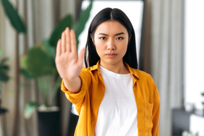 Young Chinese woman making a "stop" gesture to the camera.