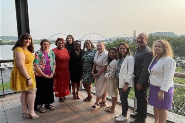 RALIANCE team posed on a deck with the DC river behind them.