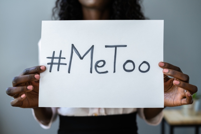 Black woman holding sign that says "#MeToo"