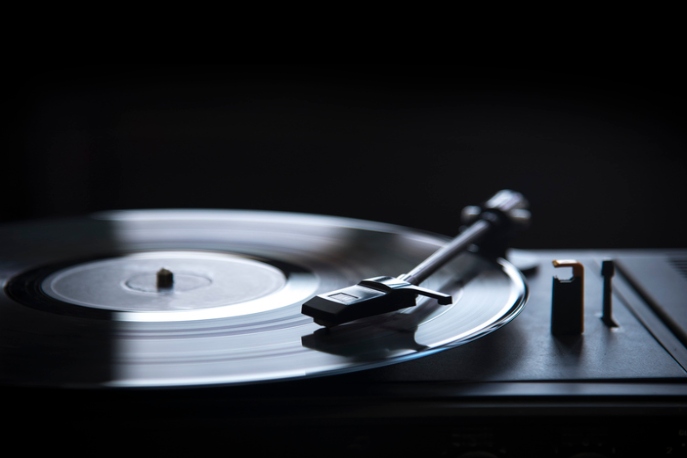 Retro gramophone vinyl player over black background